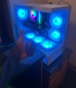 A thumbs-up in front of a white case with blue fans glowing, on a customer desk.
